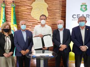 Camilo Santana assinando protocolo de intenção para projetos de hidrogênio verde no ceará durante live no palácio da abolição