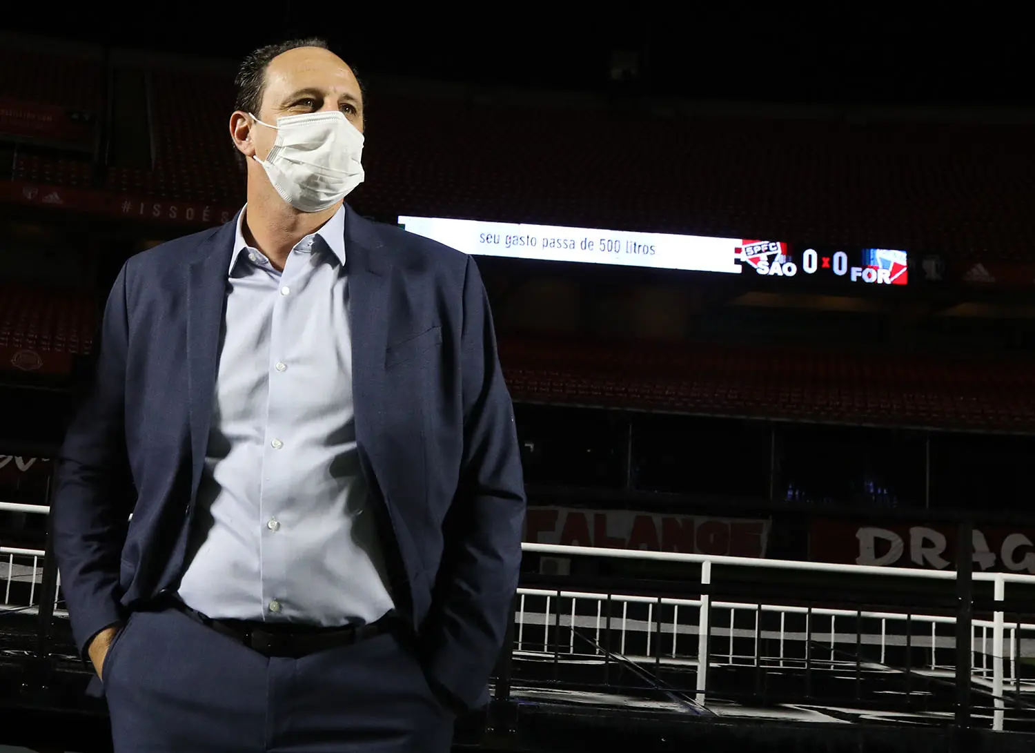 Rogério Ceni de terno em frente a placar do São Paulo contra Fortaleza, em 0 a 0