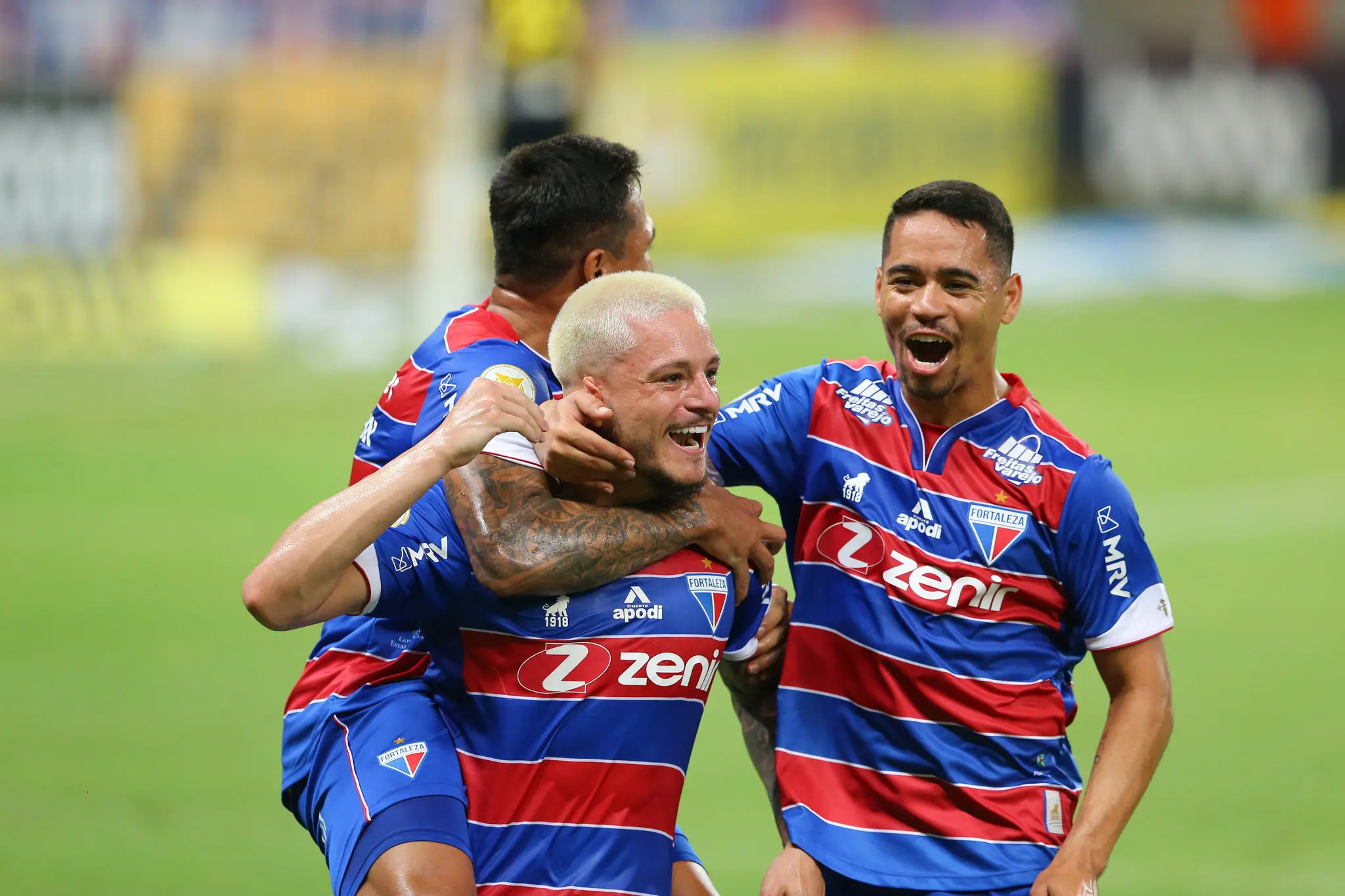 Lucas Crispim, Robson e Pikachu se abraçam em comemoração de gol