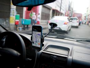 Carro parado no trânsito, com celular posicionado no vidro do carro