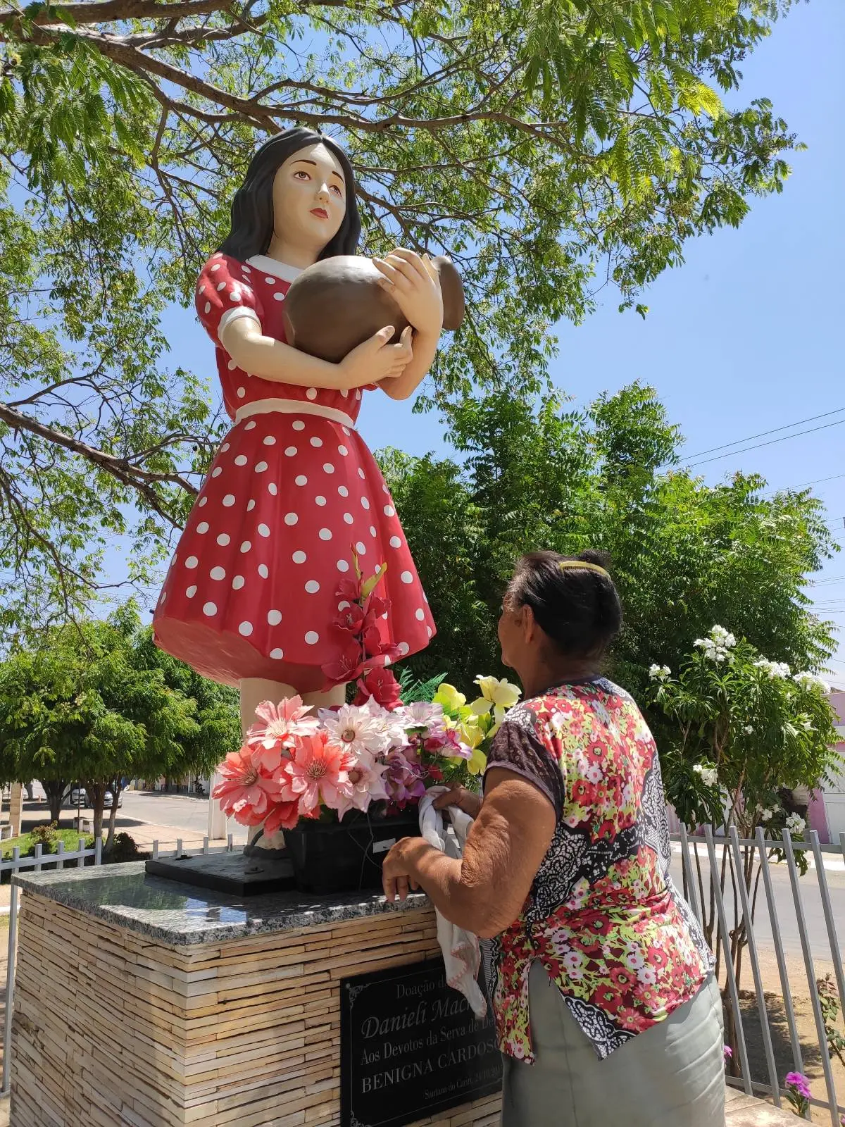 Aposentada Maria Júlia da Silva cuidando do monumento dedicado a Benigna