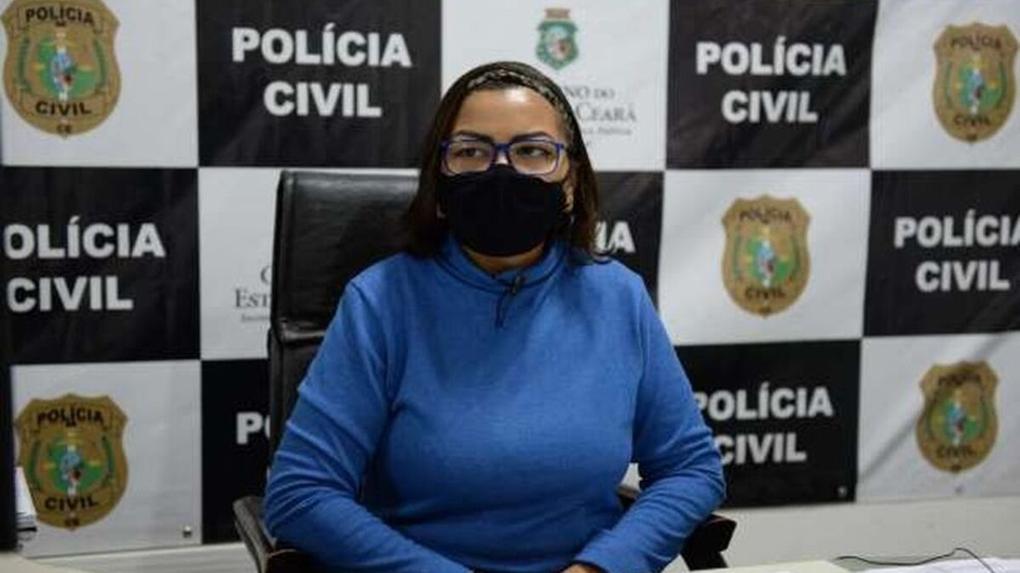 A advogada, vítima responsável por denunciar caso de racismo em uma loja da Zara, sentada à frente de um painel da Polícia Civil