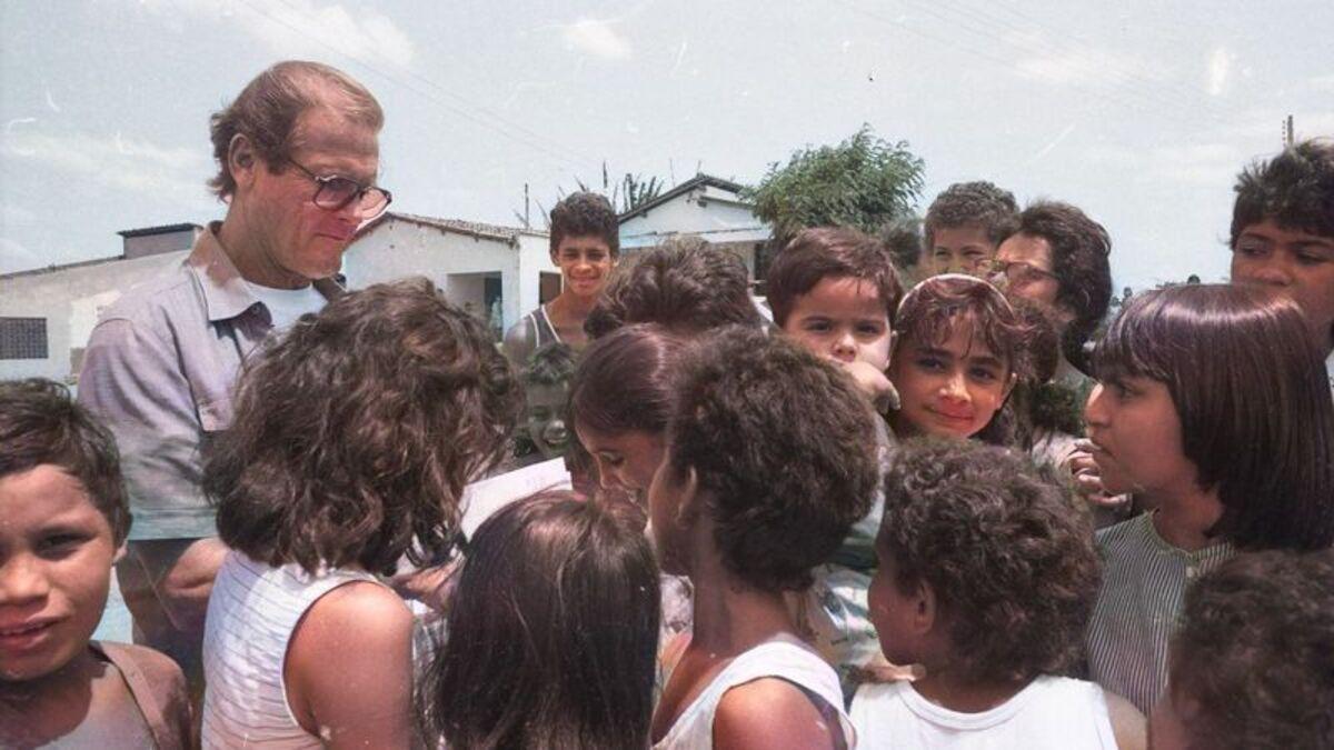 Ator Roger Moore distribuindo autógrafos para crianças no Ceará