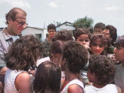 Ator Roger Moore distribuindo autógrafos para crianças no Ceará