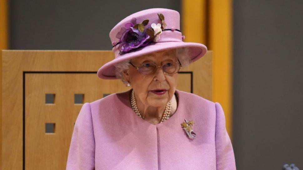 rainha elizabeth II vestindo chapéu e traje rosa