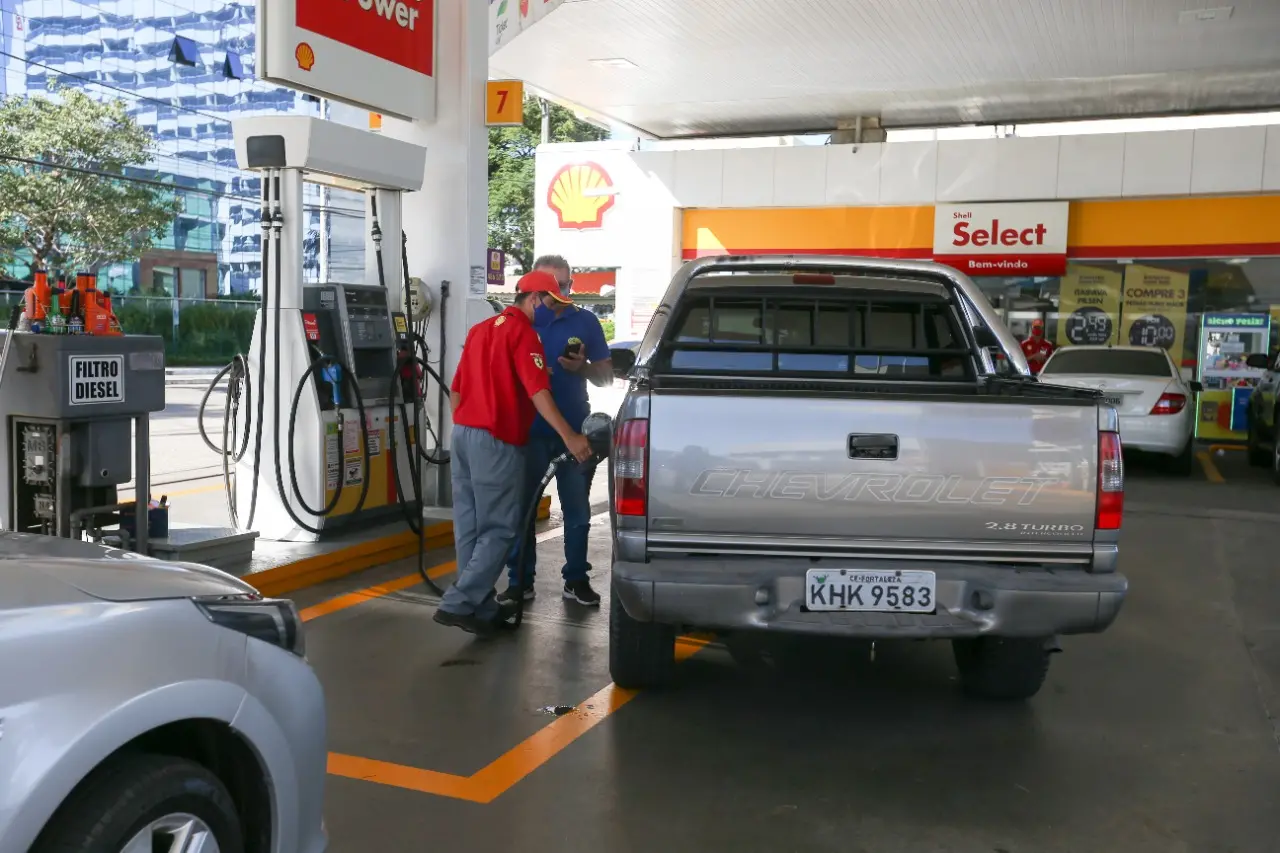 frentista abastecendo carro em posto de gasolina