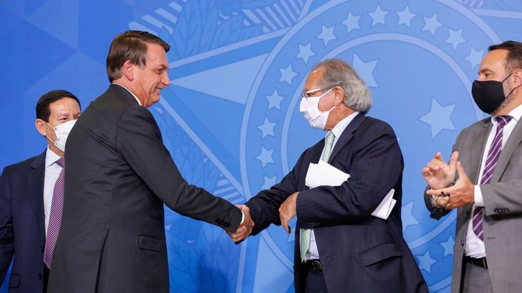 O presidente da República Jair Bolsonaro aperta a mão do ministro da Economia Paulo Guedes.