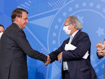 O presidente da República Jair Bolsonaro aperta a mão do ministro da Economia Paulo Guedes.