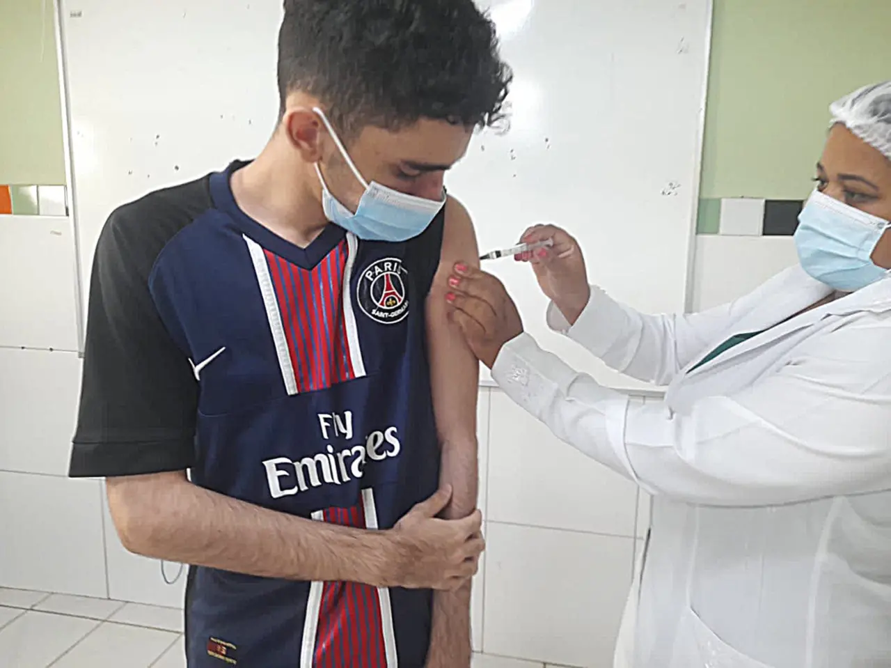 Adolescente tomando a vacina contra a Covid-19 em Fortaleza, no Ceará