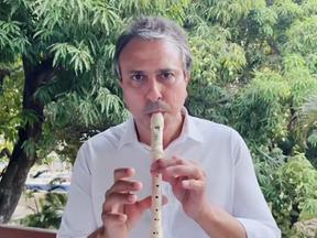 Camilo Santana tocando flauta