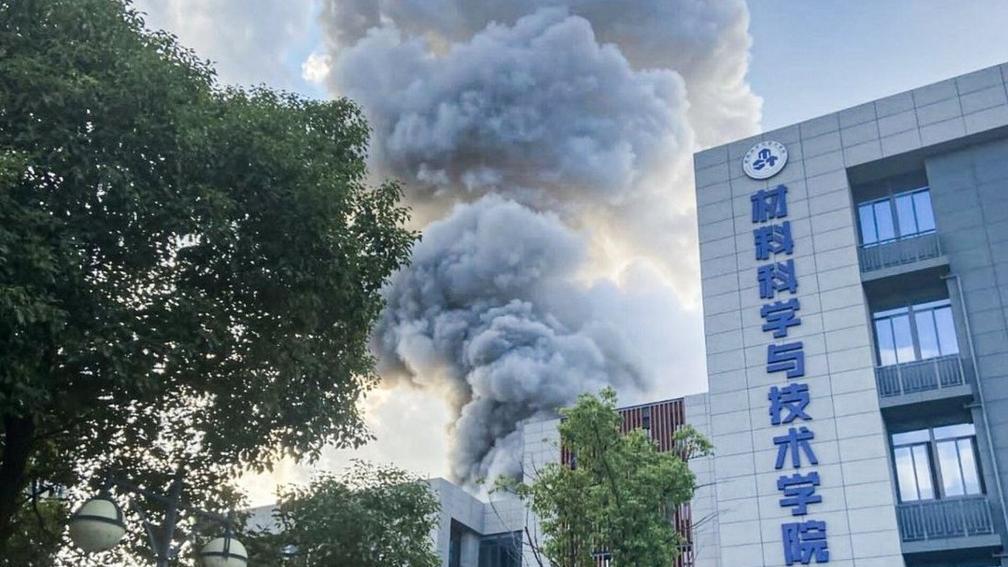 Coluna de fumaça encobrindo parte do prédio da universidade