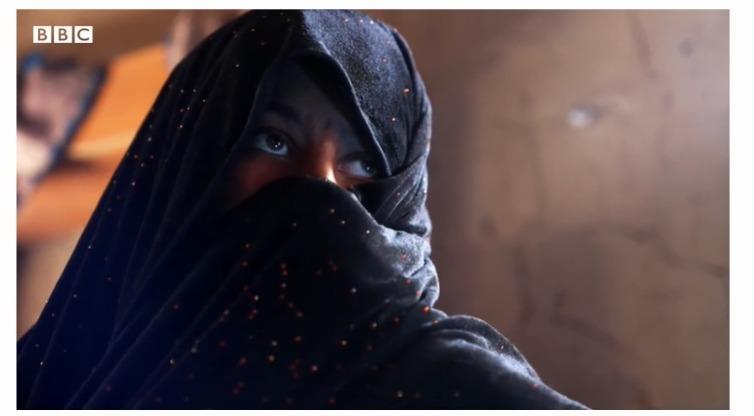 Mãe coberta com véu durante entrevista