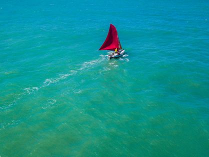 Barco de vela vermelha no mar