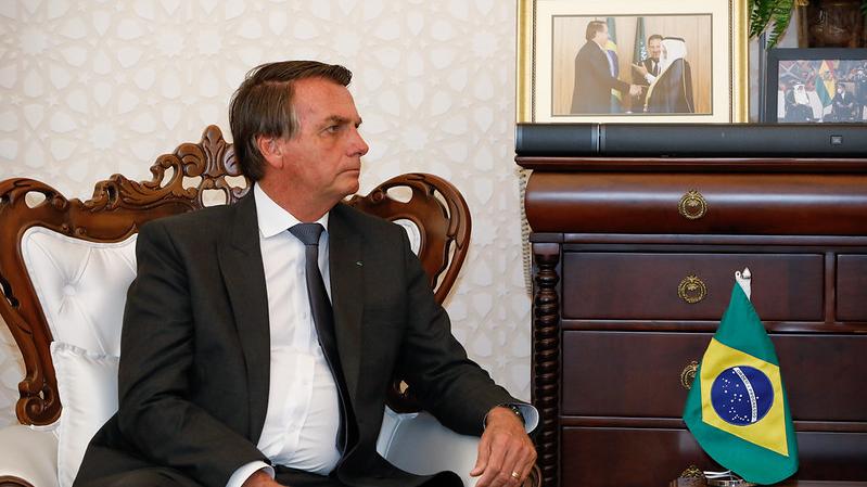 O presidente Jair Bolsonaro está sentado, de perfil.