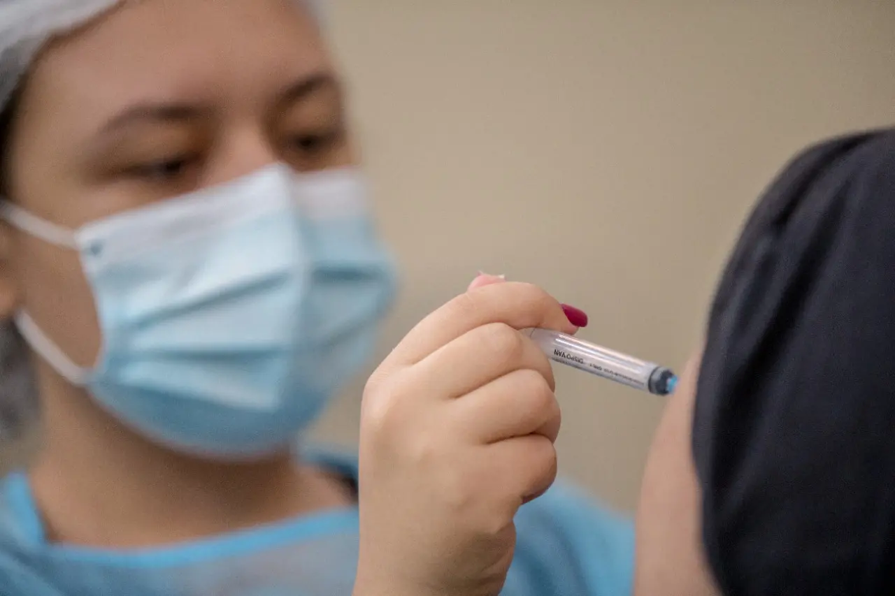 profissional da saúde vacinando paciente