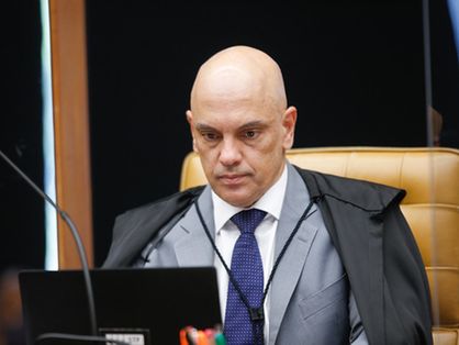 Ministro do STF Alexandre de Moraes está concentrado olhando para o computador.