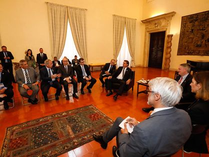 O presidente Jair Bolsonaro está sentado numa poltrona numa sala onde estão reunidos os líderes do G20.