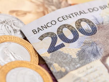 A imagem mostra uma cédula de 200 reais ao lado de moedas.
