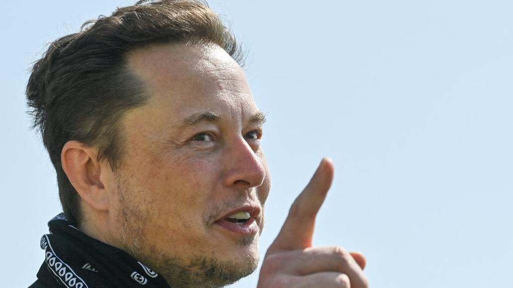 Bilionário Elon Musk falando com dedo indicador em riste