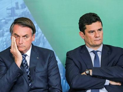 O presidente Jair Bolsonaro está sentado ao lado do ex-ministro da Justiça e ex-aliado Sergio Moro.