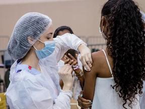 Profissional de saúde aplicando a vacina contra a Covid-19 em mulher em Fortaleza