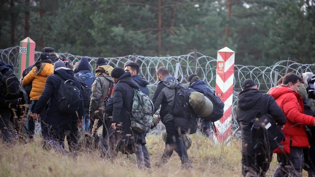 Imigrantes tentando entrar em território polonês, cercado com diversos arames