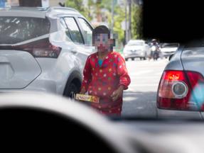 Criança vestida de palhaço vendendo doces na rua