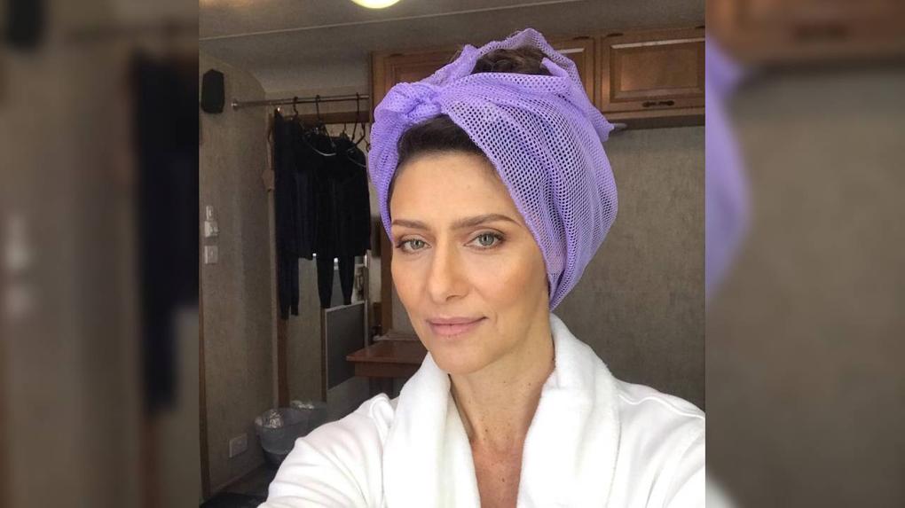 Maria Fernanda Cândido com toalha na cabeça em set de filmagem