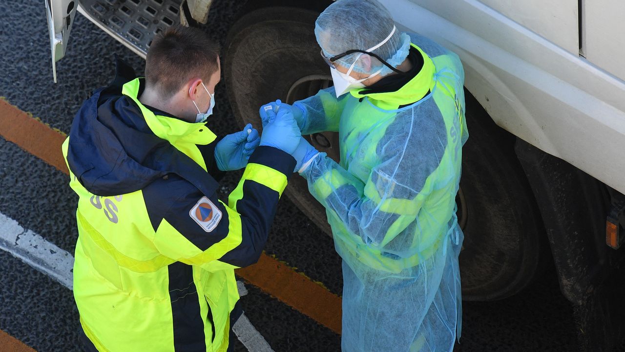 ‎Membros da Federação Francesa de Resgate e Primeiros Socorros (FFSS) realizando testes da Covid-19 em motoristas de caminhão, na costa sudeste da Inglaterra
