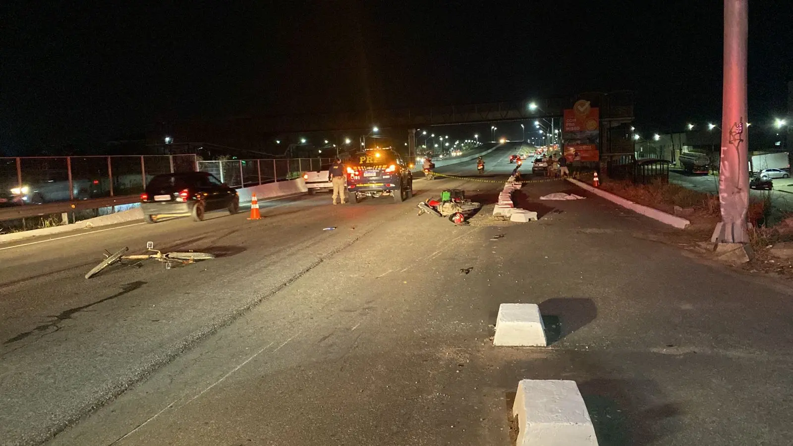 BR-222 com uma moto e uma bicicleta ao chão, durante a noite, após um motociclista matar uma criança atropelada em Caucaia