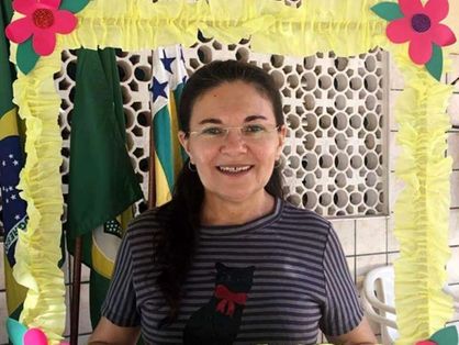 A imagem mostra a professora Núbia Rocha, da Escola de Ensino Médio (EEM) Nazaré Severiano, de óculos e cabelos amarrados num rabo de cavalo, sorrindo, dentro de uma moldura colorida com o nome Spaece embaixo.