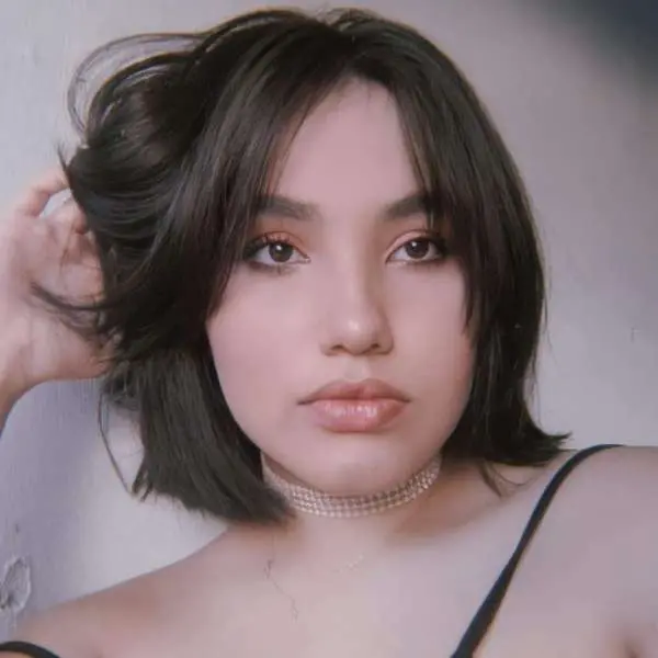 A imagem mostra a estudante Millena Évila da Silva séria, com a mão nos cabelos.