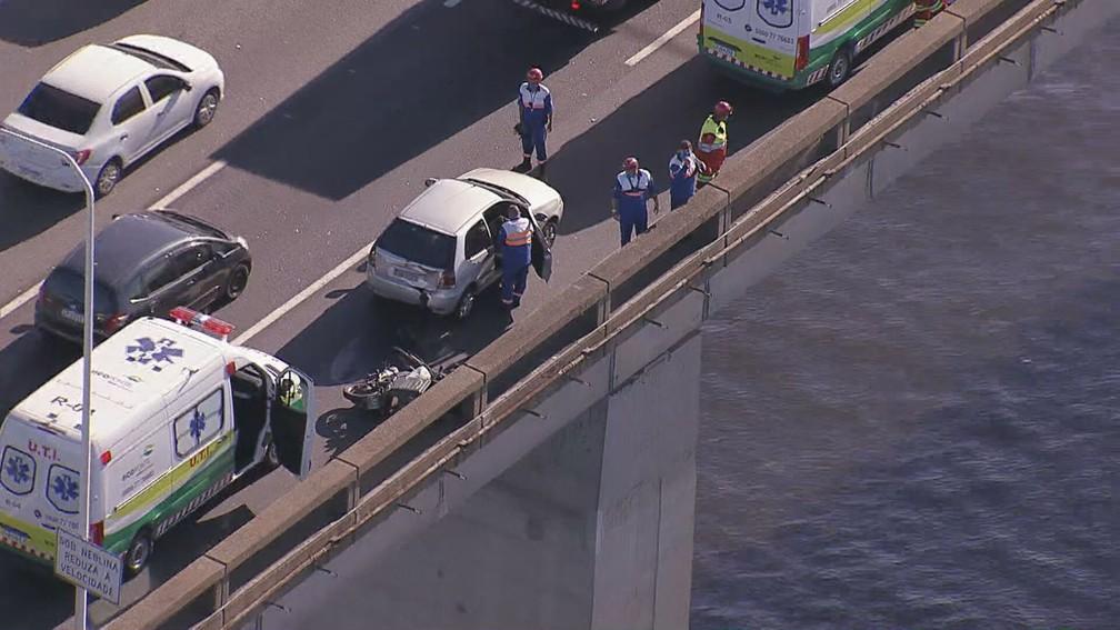 Vista de helicóptero de acidente na Ponte Rio-Niterói. Carros e ambulâncias estão parados, e socorristas fazem atendimento