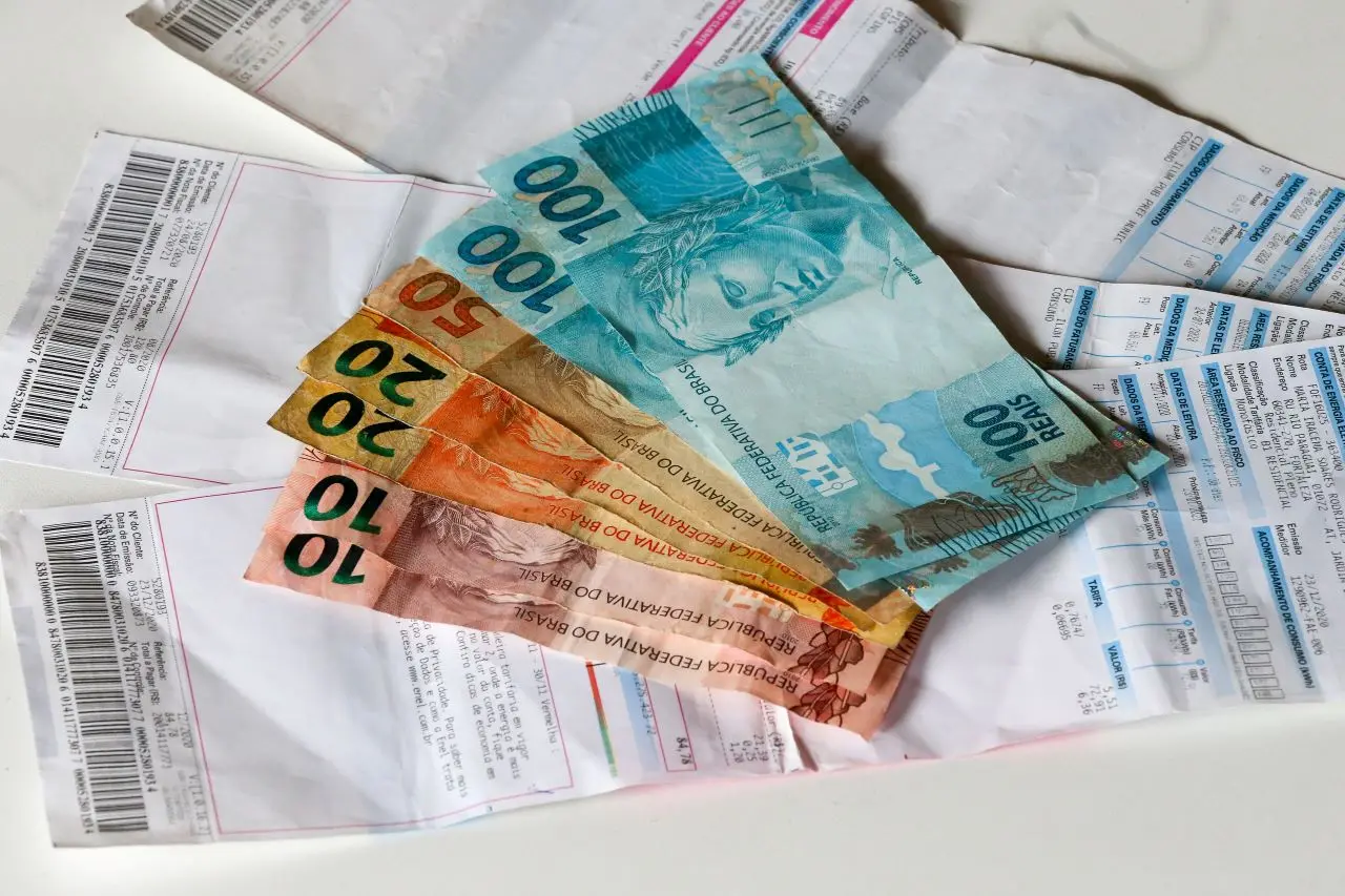 contas de energia com notas de dinheiro em cima