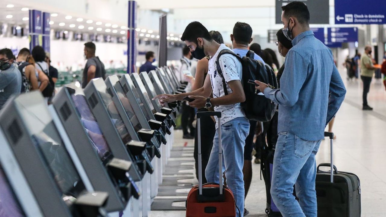 Passageiros com bagagens fazendo autoatendimento no Aeroporto de Fortaleza