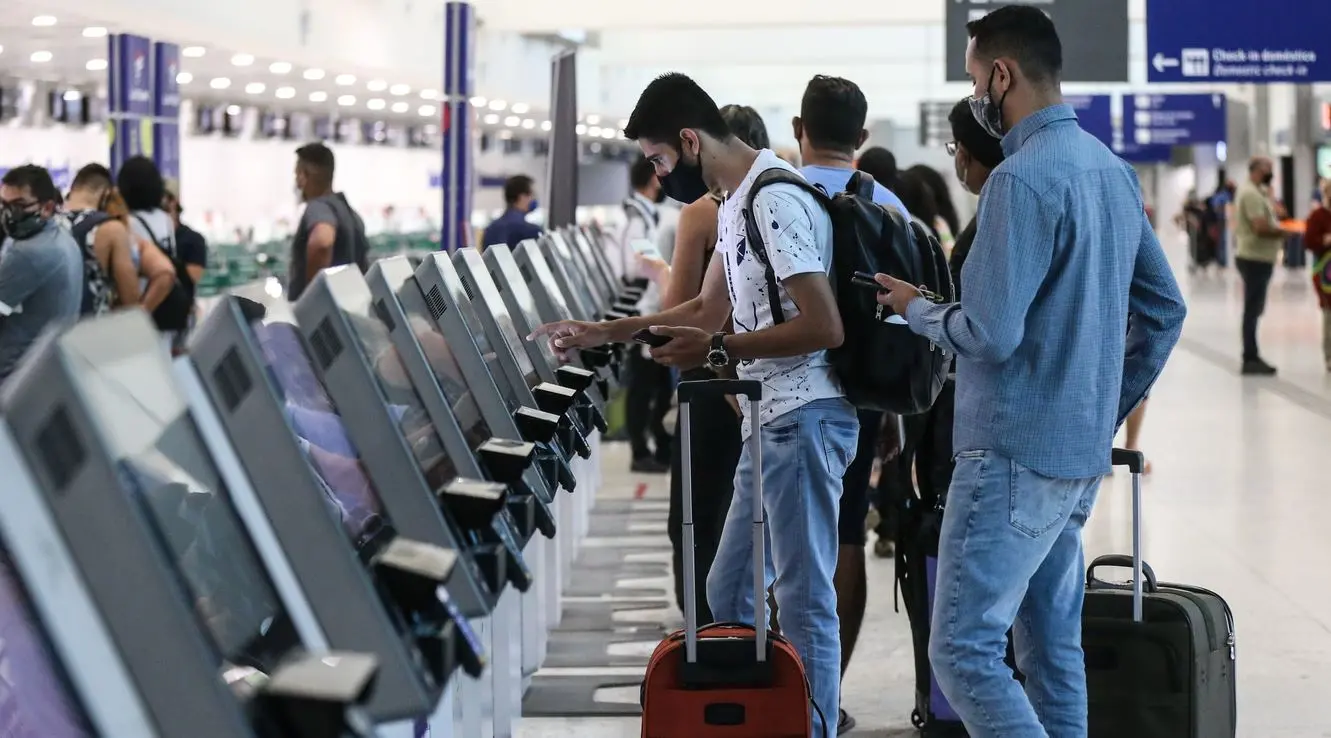 Passageiros com bagagens fazendo autoatendimento no Aeroporto de Fortaleza