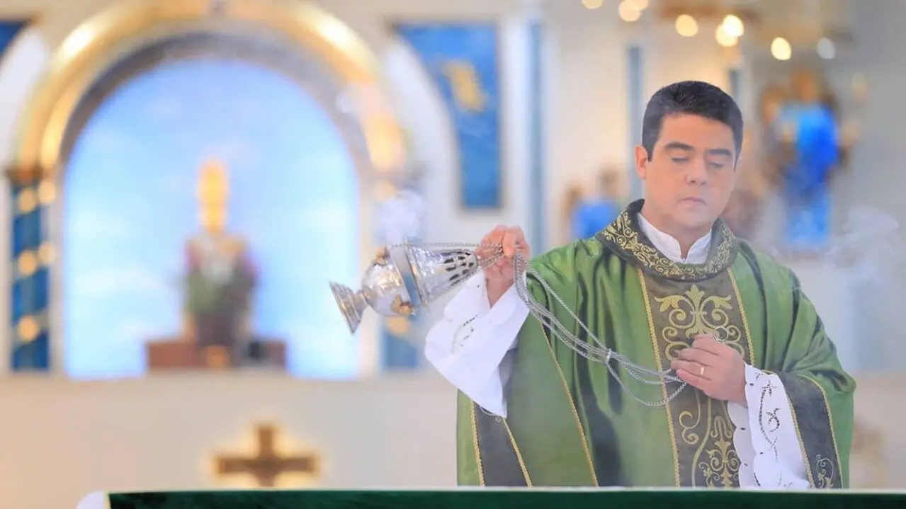 Padre Robson manejando item religioso em igreja