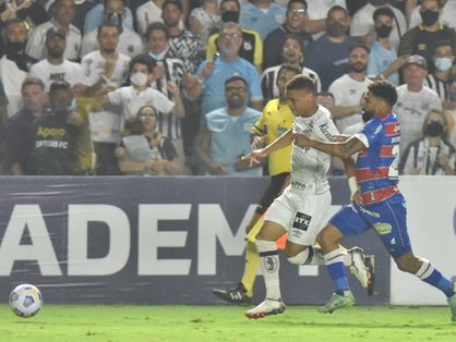 Romarinho disputa bola com jogador do Santos na Vila Belmiro em duelo pela Série A