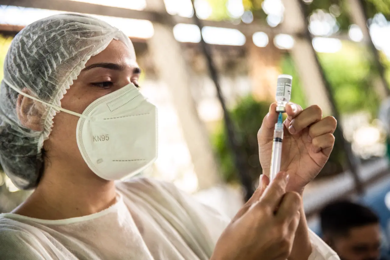 enfermeira preparando aplicação de dose de vacina contra a covid-19