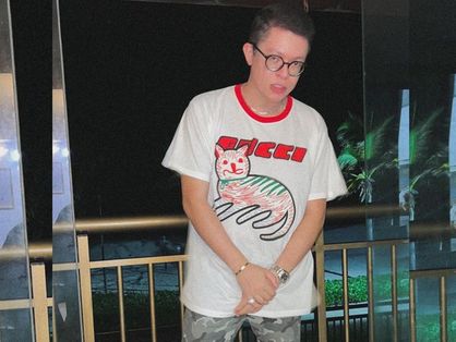 A imagem mostra o DJ Ivis de frente, de camisa branca e calça camuflada.