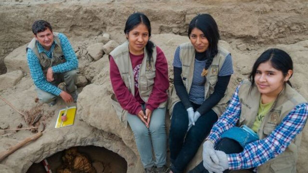 Pesquisadores ao lado da múmia encontrada no Peru