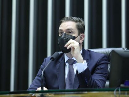 A imagem mostra o deputado federal cearense Eduardo Bismarck ao microfone, de terno e máscara.