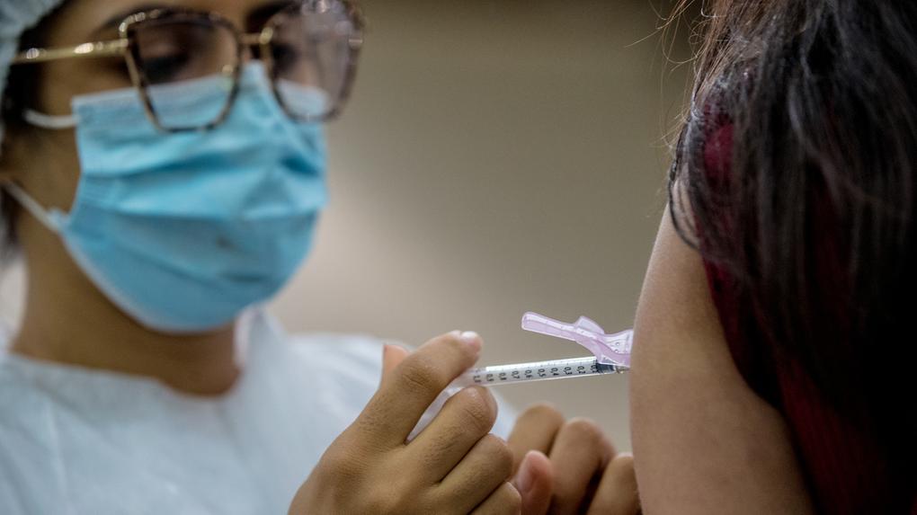 Profissional da saúde vacina pessoa contra Covid-19 no Centro de Eventos do Ceará, em Fortaleza