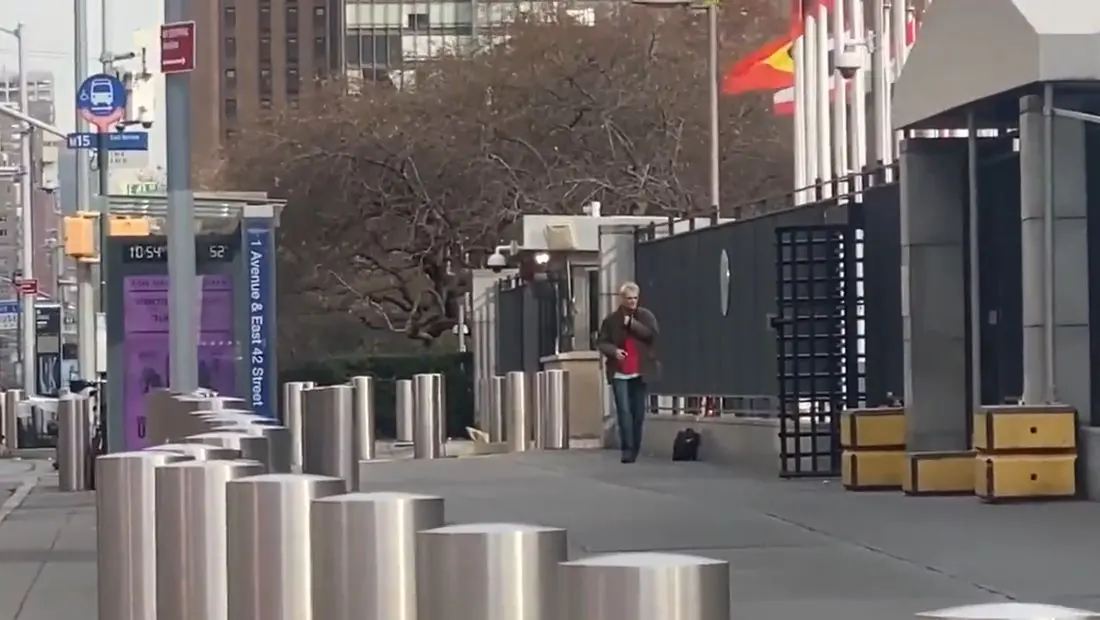 homem aparece na calçada da sede da onu, em nova york. ao seu redor não há mais ninguém.