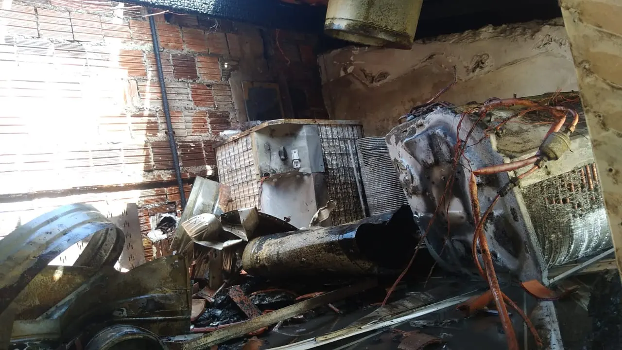 A imagem mostra estruturas de ar-condicionado danificadas pelo incêndio.