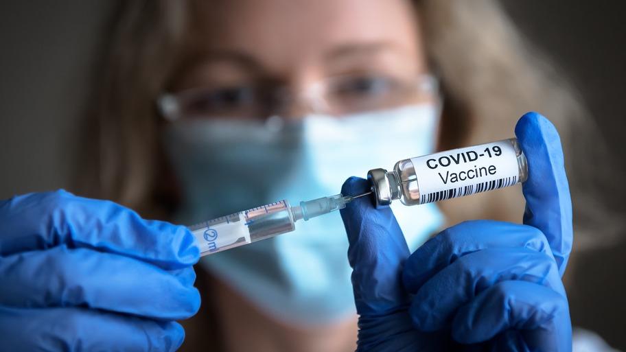 Mulher segura vacina contra a Covid-19.