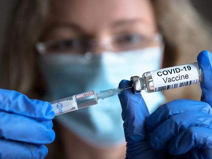 Mulher segura vacina contra a Covid-19.