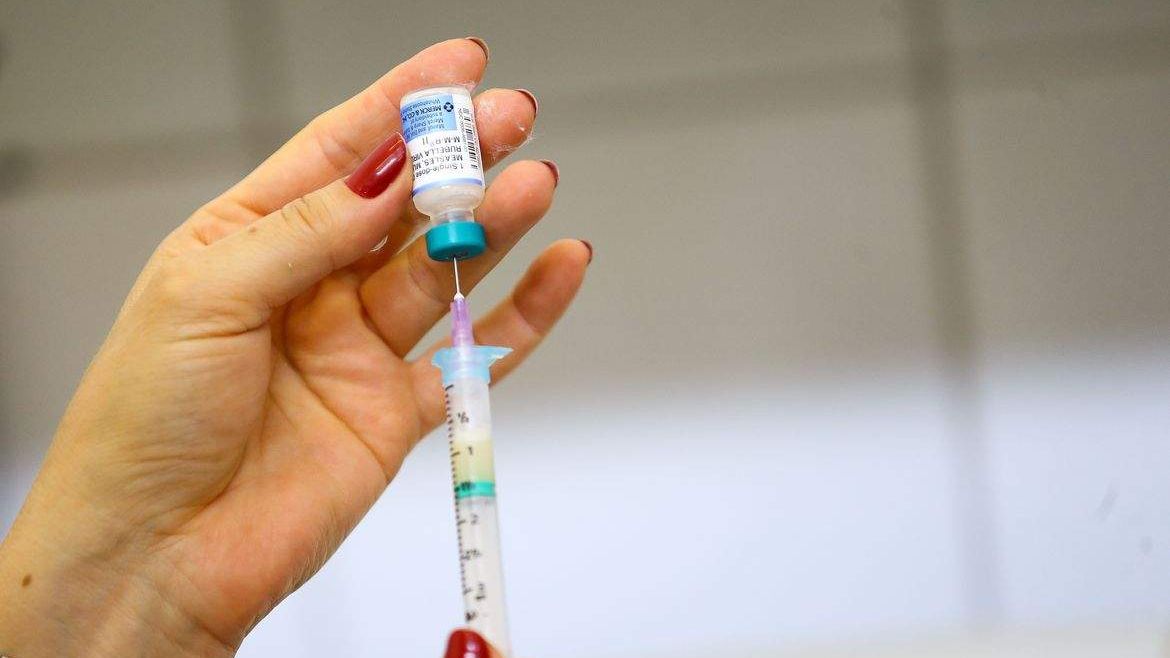 Profissional de saúde segurando seringa com vacina contra a Covid-19