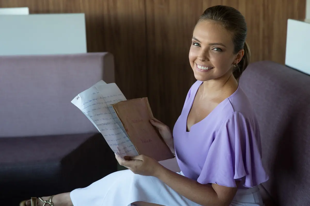 Taís segurando a carta