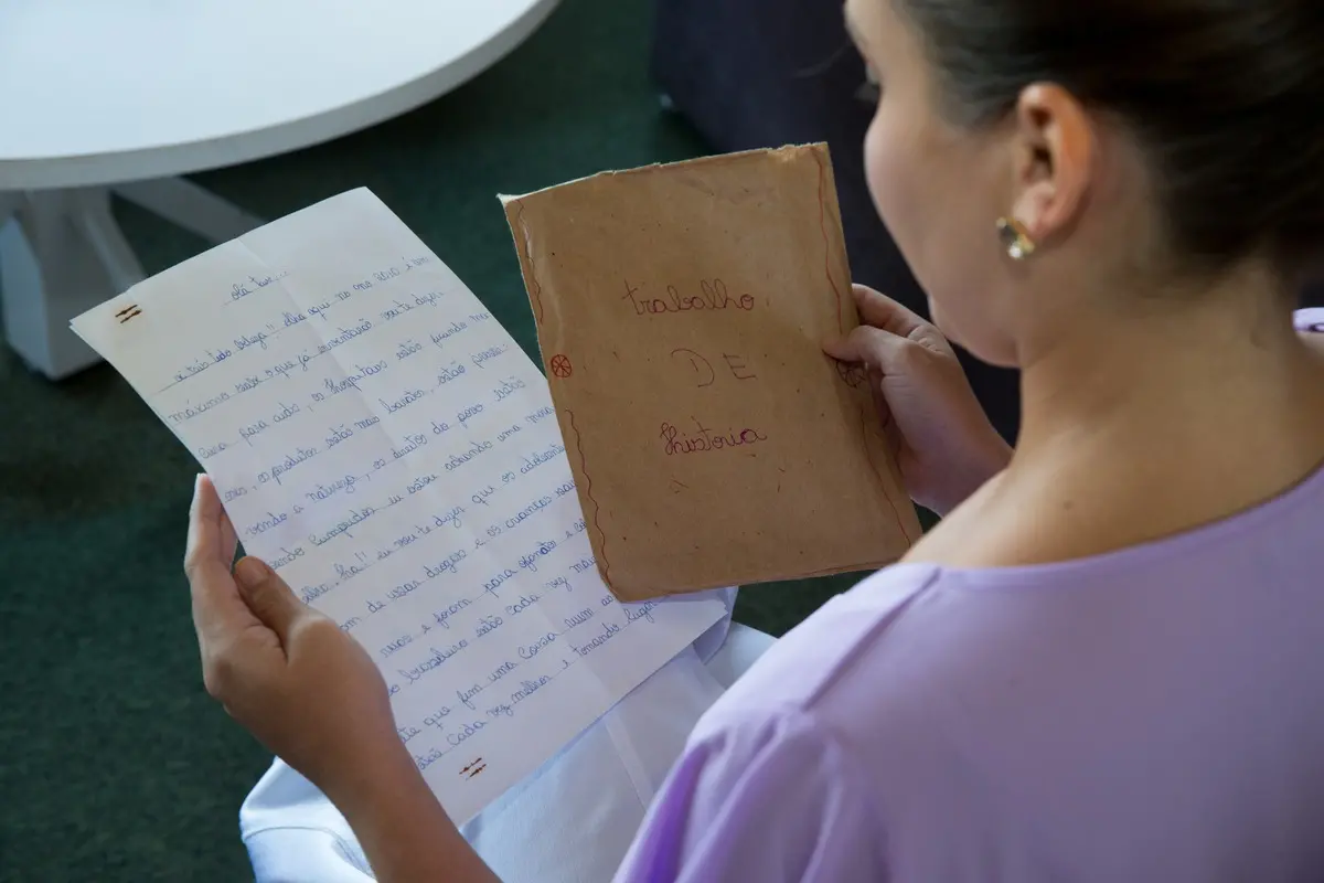 De costas, Taís lê a carta